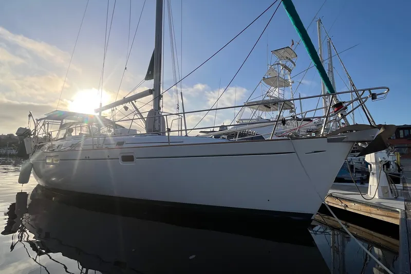 Slide: The Image of 2001 Beneteau Oceanis 461 sailboat docked at sunset, reflecting on calm water. - 60