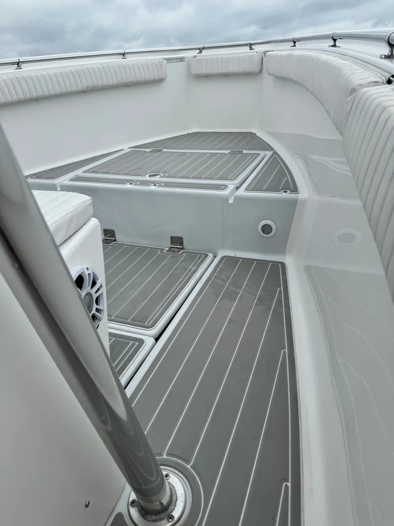 Slide: The Image of The image shows the deck of a 2005 Topaz 24 boat with gray flooring panels. - 15