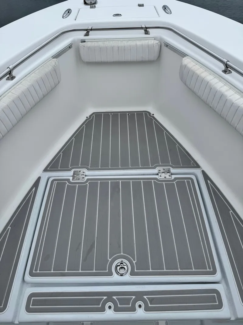 Slide: The Image of The image shows the bow deck of a 2005 Topaz 24 boat with gray flooring. - 14