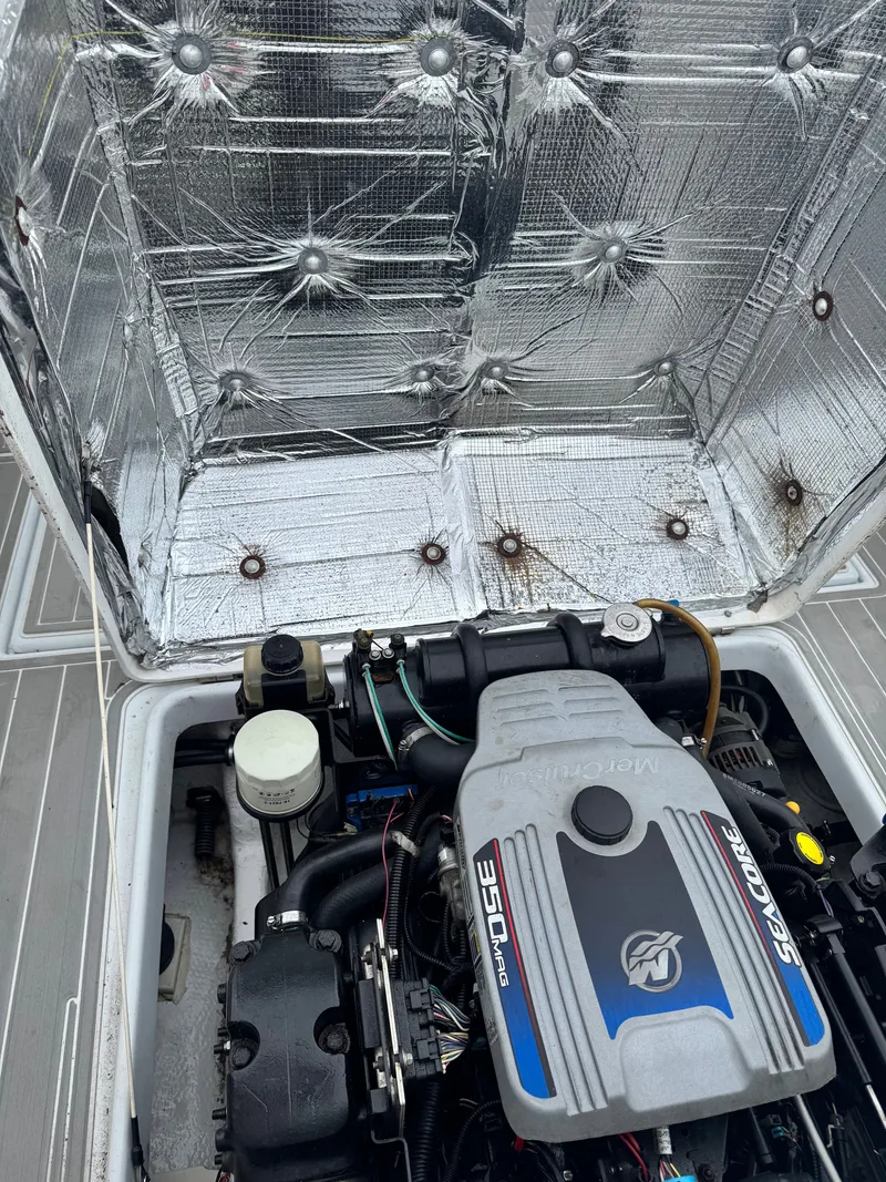 Slide: The Image of Engine compartment of a 2005 Topaz 24 boat with open cover and visible engine. - 18