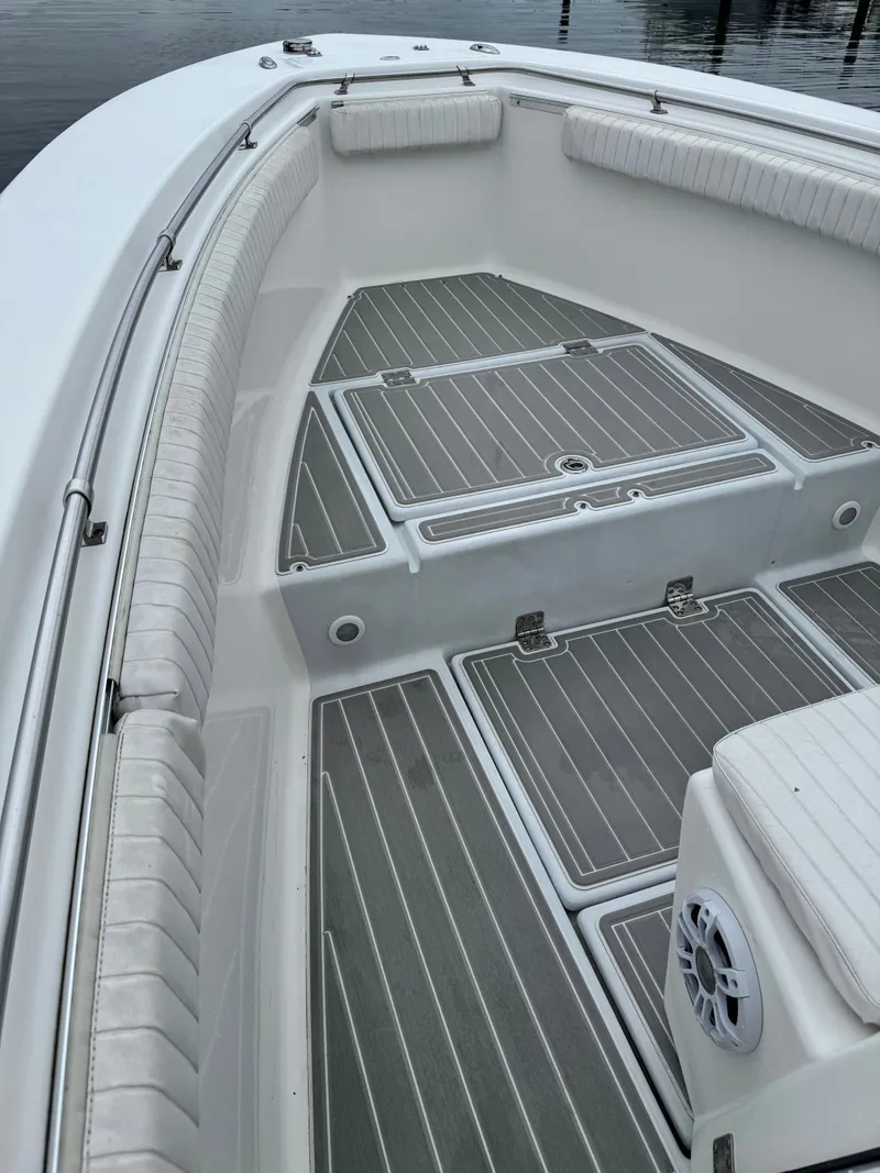 Slide: The Image of The image shows the bow deck of a 2005 Topaz 24 boat with cushioned seating. - 13