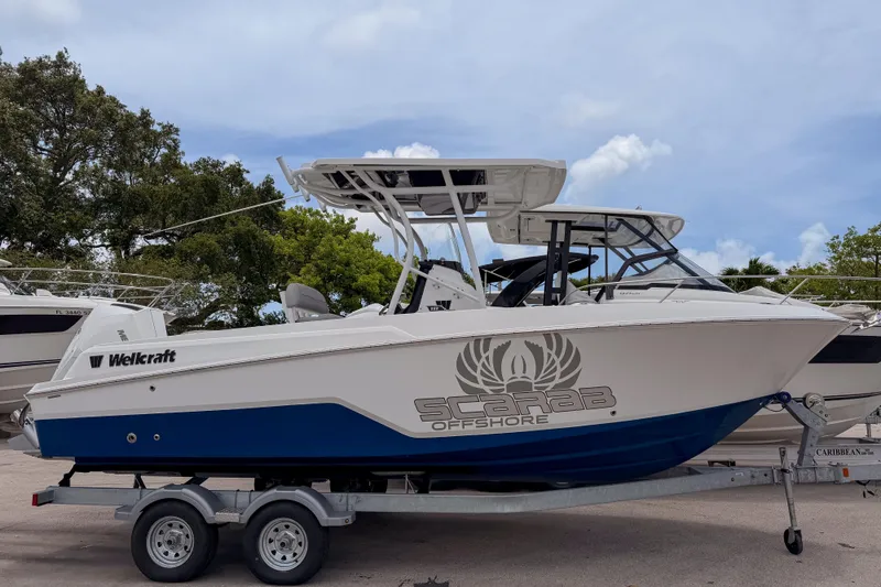 The Image of 2023 Wellcraft 222 Fisherman boat on trailer, featuring Scarab Offshore branding. - 0