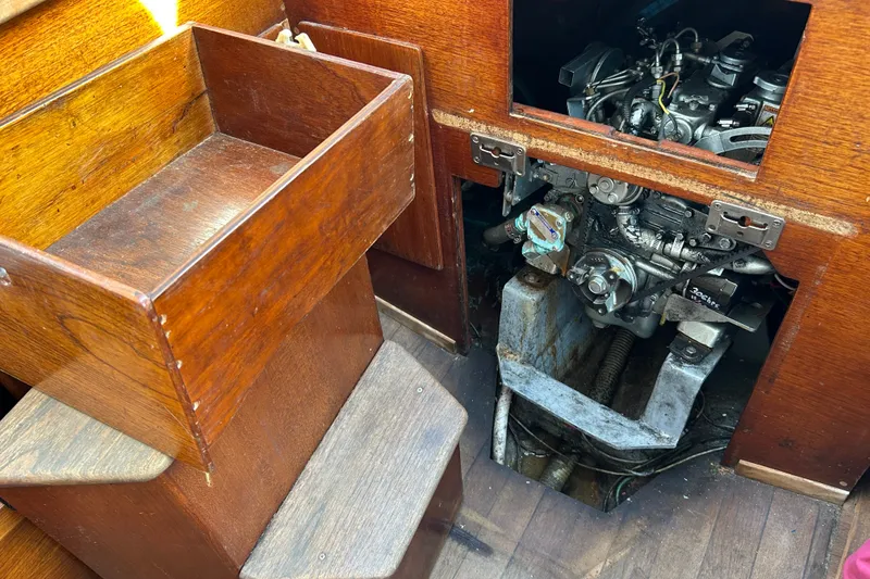 Slide: The Image of 1976 Sabre 28 sailboat engine compartment with wooden interior and visible engine components. - 34