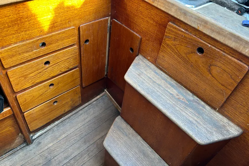 Slide: The Image of Interior of a 1976 Sabre 28 sailboat featuring wooden cabinetry and steps. - 38