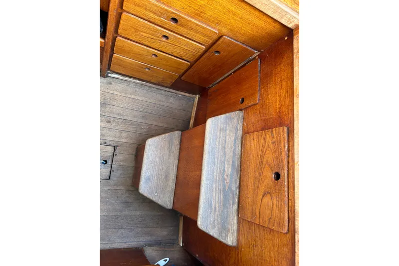 Slide: The Image of Wooden interior of a 1976 Sabre 28 sailboat, featuring storage compartments and seating. - 39