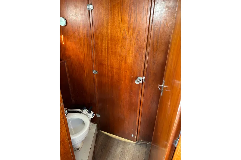 Slide: The Image of 1976 Sabre 28 sailboat interior with wooden paneling and compact marine toilet. - 41