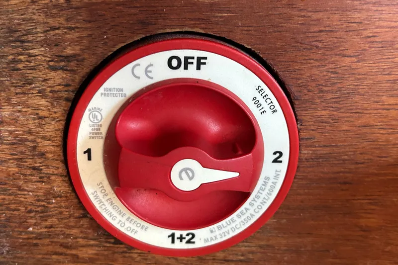 Slide: The Image of Red marine battery switch on a 1976 Sabre 28 boat, labeled "Blue Sea Systems." - 50