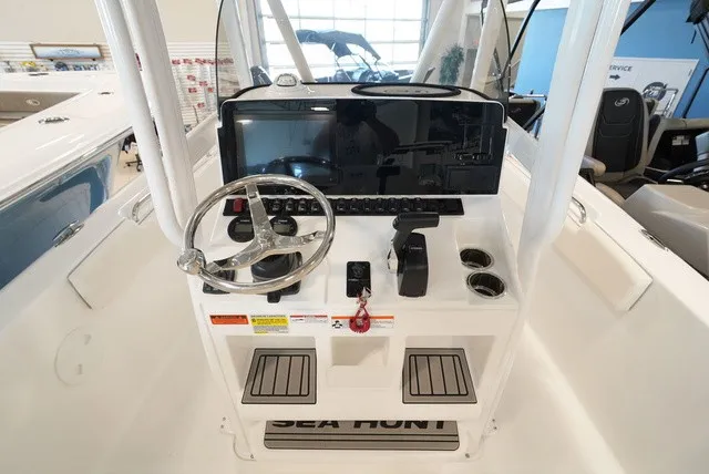 Slide: The Image of The image shows the helm of a Sea Hunt Ultra 229 boat with steering wheel and instruments. - 19