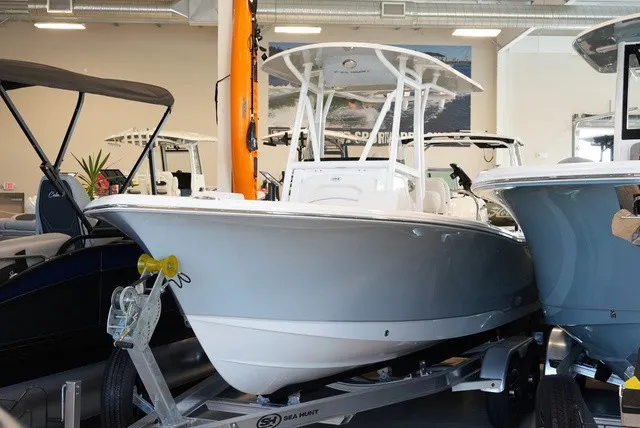 The Image of A 2027 Sea Hunt Ultra 229 boat is on a trailer in a showroom. - 1