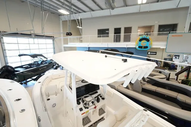 Slide: The Image of 2027 Sea Hunt Ultra 229 in a showroom with other boats. - 15