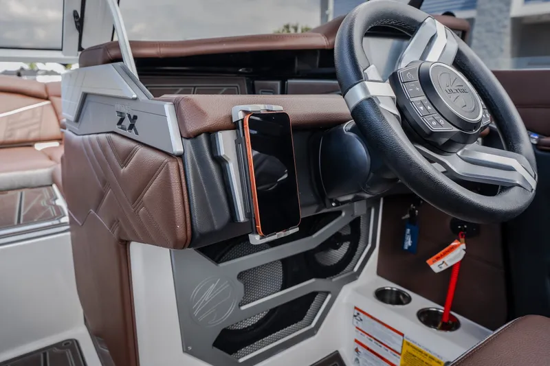 Slide: The Image of 2026 Tigé Ultré 25ZX boat interior with steering wheel and smartphone holder. - 44
