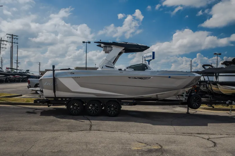 Slide: The Image of 2026 Tigé Ultré 25ZX boat on trailer under a cloudy sky at a dealership. - 57