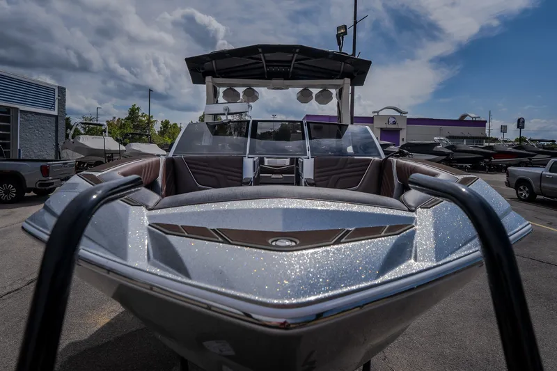 Slide: The Image of 2026 Tigé Ultré 25ZX boat with sleek design and metallic finish, parked outdoors. - 6