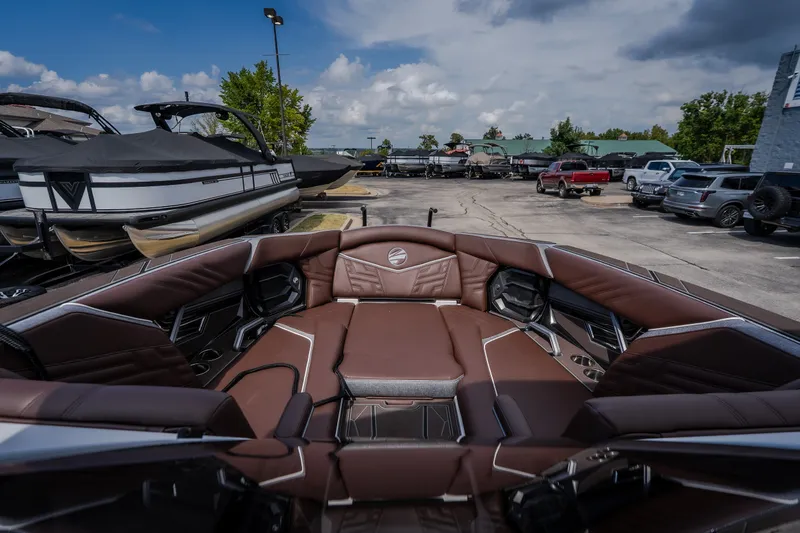 Slide: The Image of 2026 Tigé Ultré 25ZX boat interior with luxurious brown seating, parked in a marina. - 48