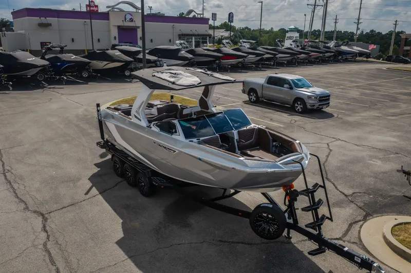 Slide: The Image of 2026 Tigé Ultré 25ZX boat on trailer in parking lot, surrounded by other boats. - 59