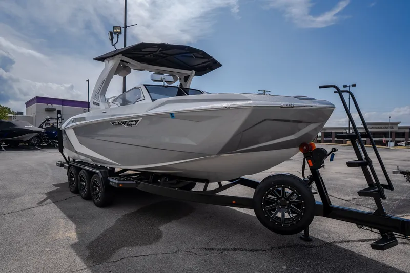 Slide: The Image of 2026 Tigé Ultré 25ZX boat on trailer under cloudy sky. - 5