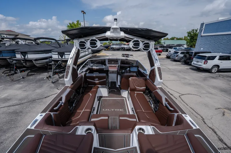 Slide: The Image of 2026 Tigé Ultré 25ZX boat with luxurious brown seating and modern design in a marina. - 22