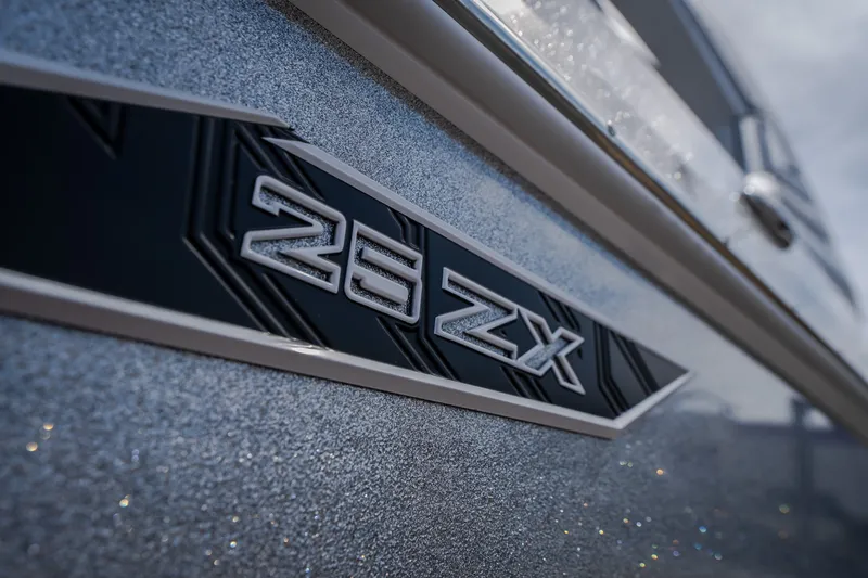 Slide: The Image of 2026 Tigé Ultré 25ZX boat emblem on metallic surface. - 16