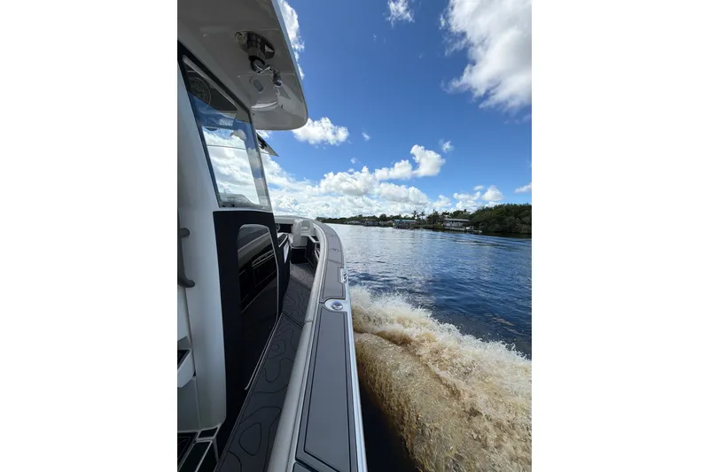 Slide: The Image of 2021 Solace 345CC boat cruising on a sunny day, view from the deck. - 16