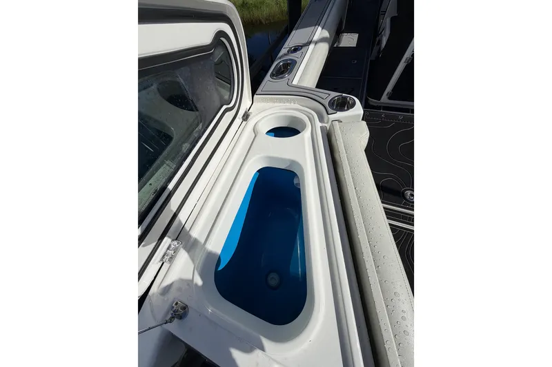Slide: The Image of 2021 Solace 345CC boat interior with storage compartment and cup holders. - 43
