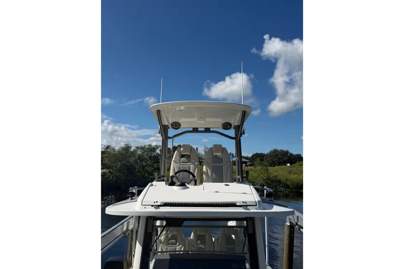 Slide: The Image of 2021 Solace 345CC boat helm with seating, under clear blue sky. - 19