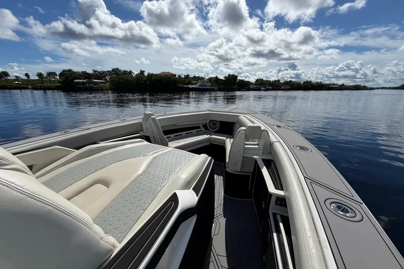Slide: The Image of 2021 Solace 345CC boat interior with luxurious seating on a calm lake. - 14