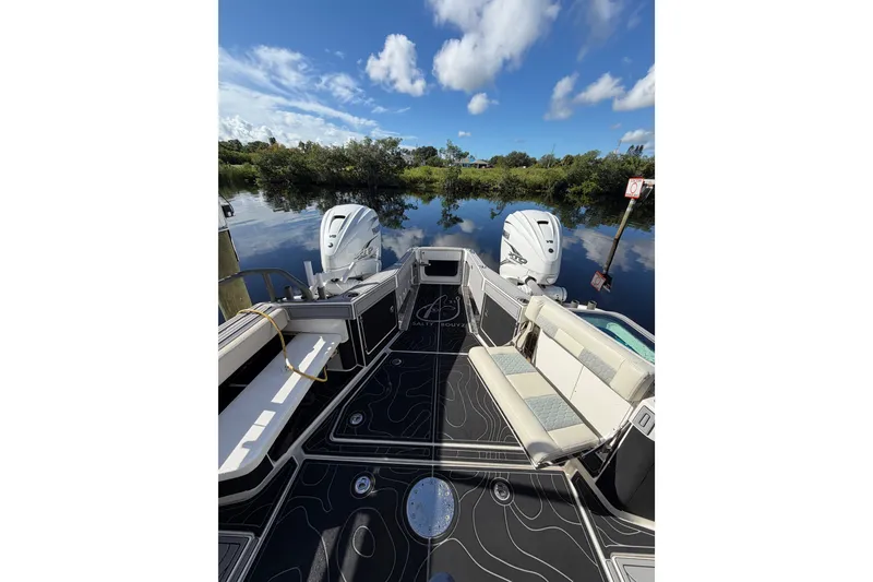 Slide: The Image of 2021 Solace 345CC boat with dual engines, sleek deck design, and scenic water view. - 40