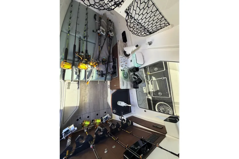 Slide: The Image of Interior of 2021 Solace 345CC boat with fishing rods and gear storage. - 32