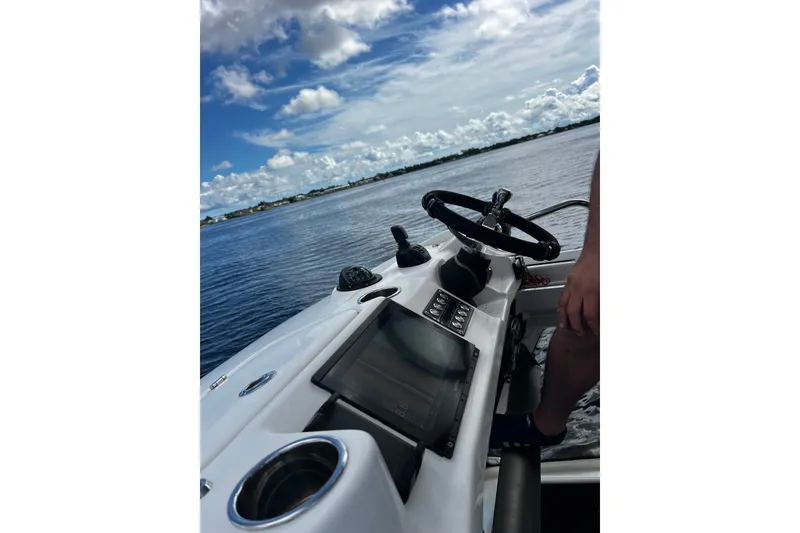 Slide: The Image of 2021 Solace 345CC boat dashboard with steering wheel on a sunny day. - 21