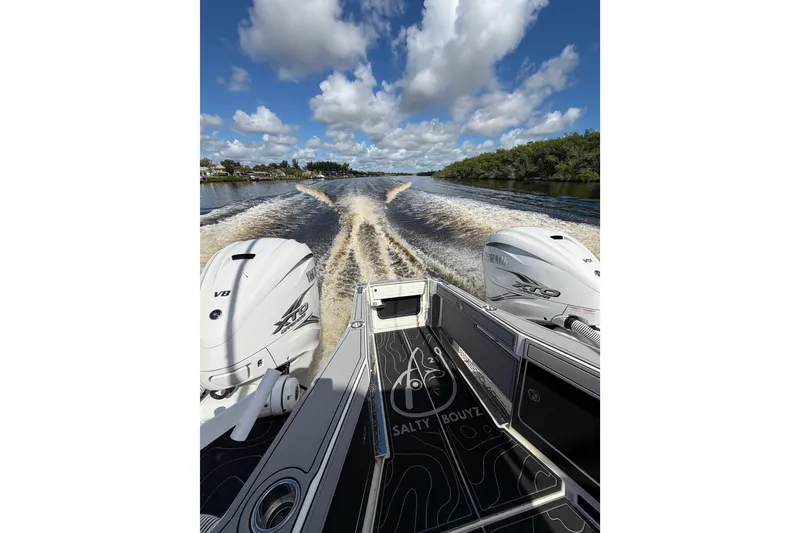 Slide: The Image of 2021 Solace 345CC boat cruising on a sunny day, twin engines, wake in water. - 39