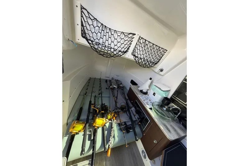Slide: The Image of Interior of 2021 Solace 345CC boat with fishing rods and storage nets. - 31