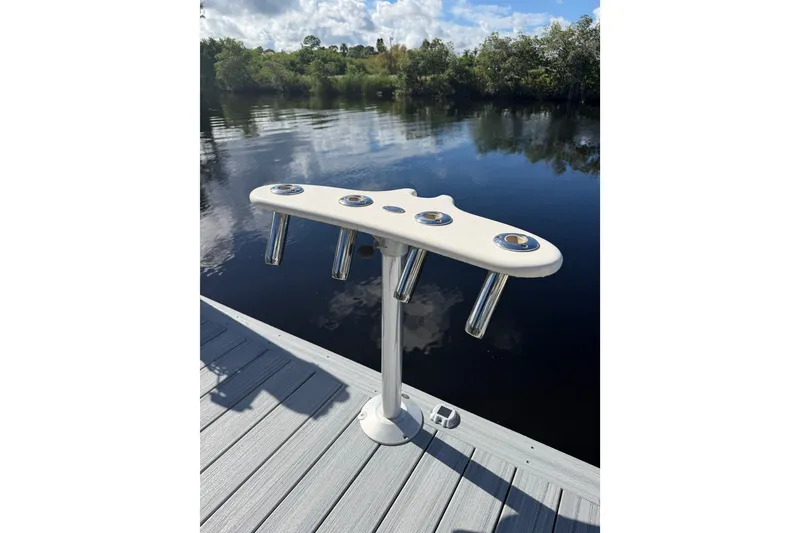 Slide: The Image of Rod holders on a dock beside a calm lake, under a partly cloudy sky. - 44