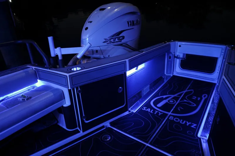 Slide: The Image of 2021 Solace 345CC boat interior with Yamaha engine, illuminated by blue LED lights. - 42