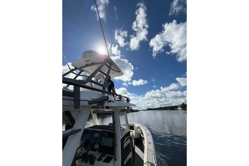 Slide: The Image of 2021 Solace 345CC boat cruising under a bright blue sky with scattered clouds. - 20