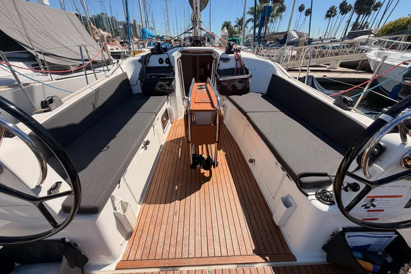 Slide: The Image of 2024 Jeanneau Sun Odyssey 380 sailboat cockpit with dual steering wheels and teak flooring. - 37