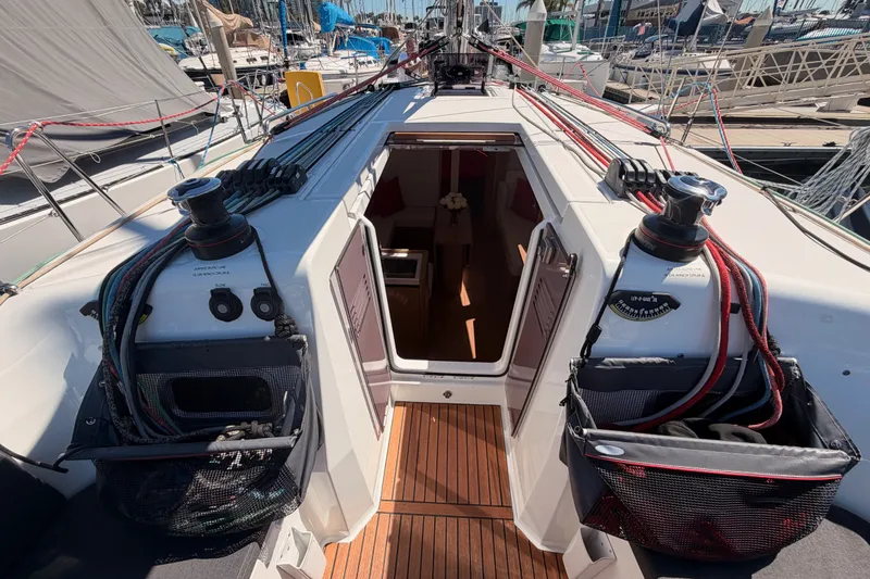 Slide: The Image of 2024 Jeanneau Sun Odyssey 380 sailboat cockpit with open cabin entrance, docked at marina. - 38
