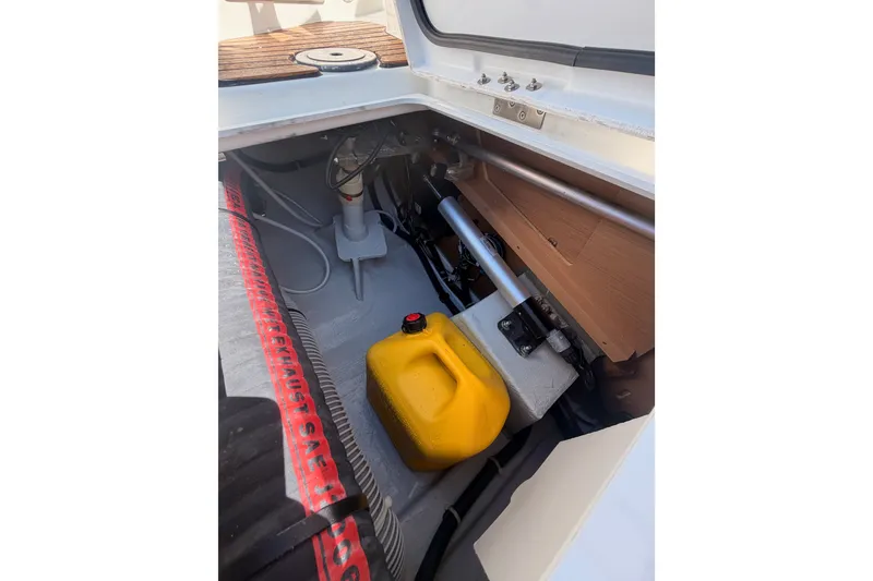 Slide: The Image of Interior view of 2024 Jeanneau Sun Odyssey 380 sailboat storage compartment with yellow fuel container. - 30