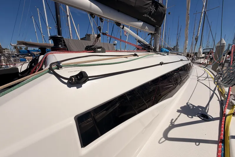 Slide: The Image of 2024 Jeanneau Sun Odyssey 380 sailboat deck with rigging and sleek design in marina. - 11