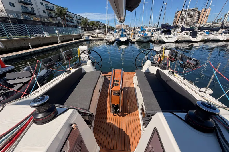 Slide: The Image of 2024 Jeanneau Sun Odyssey 380 sailboat docked in a marina, showcasing its spacious cockpit. - 23