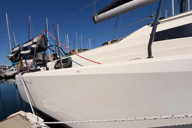 Slide: The Image of 2024 Jeanneau Sun Odyssey 380 sailboat docked in a marina under clear blue skies. - 9
