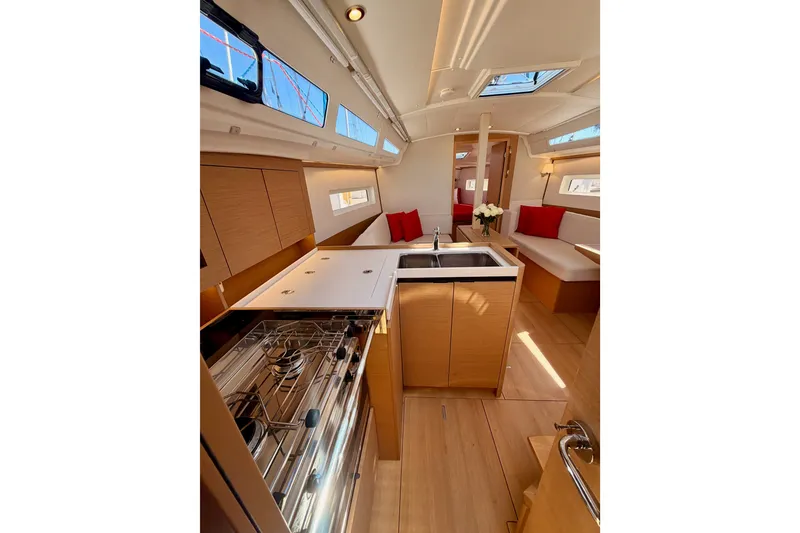Slide: The Image of Interior of 2024 Jeanneau Sun Odyssey 380 yacht, featuring modern kitchen and seating area. - 50