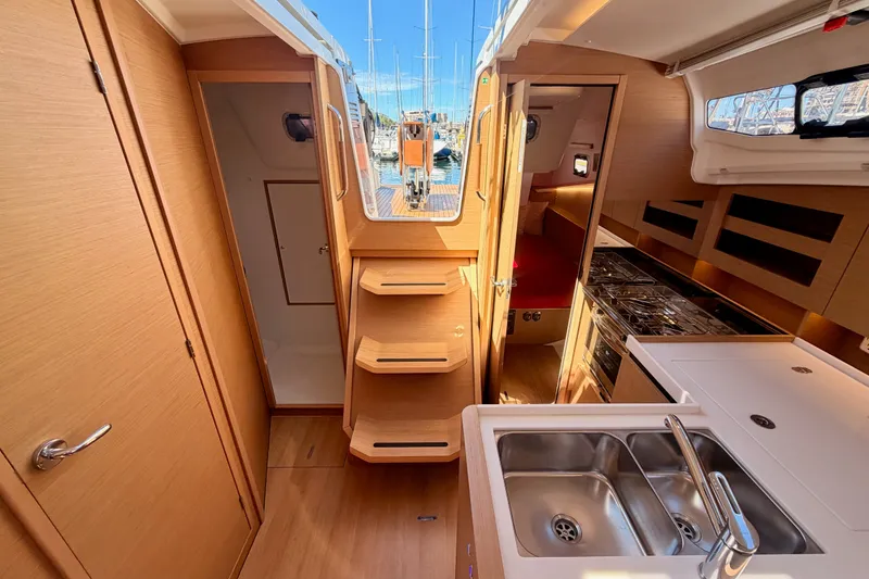 Slide: The Image of Interior of 2024 Jeanneau Sun Odyssey 380 yacht, featuring modern kitchen and wooden cabinetry. - 76
