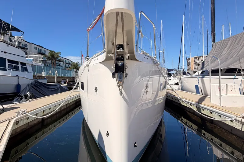 Slide: The Image of 2024 Jeanneau Sun Odyssey 380 yacht docked at marina under clear blue sky. - 5