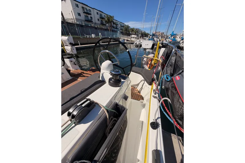 Slide: The Image of 2024 Jeanneau Sun Odyssey 380 sailboat docked, showcasing cockpit and steering wheel. - 24