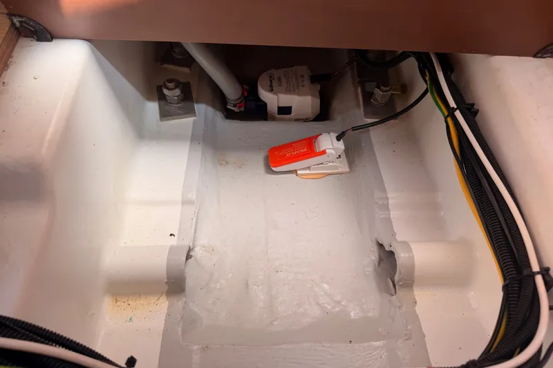 Slide: The Image of Bilge area of 2024 Jeanneau Sun Odyssey 380 sailboat, featuring wiring and pump components. - 81