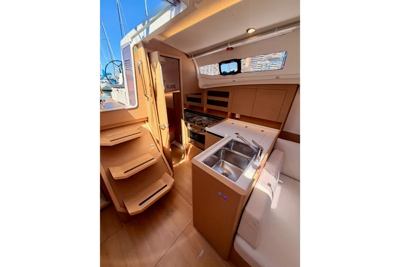 Slide: The Image of Interior of 2024 Jeanneau Sun Odyssey 380 yacht, featuring modern kitchen and wooden stairs. - 44