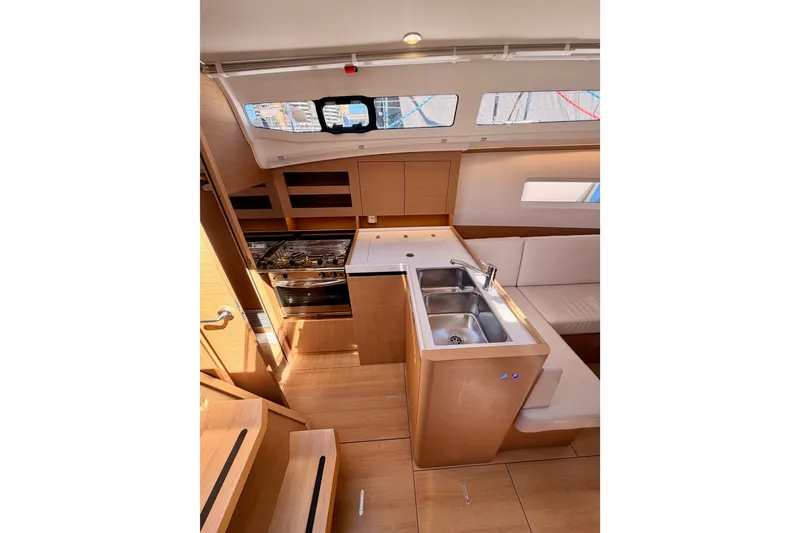 Slide: The Image of Interior of 2024 Jeanneau Sun Odyssey 380 yacht, featuring modern kitchen and seating area. - 43