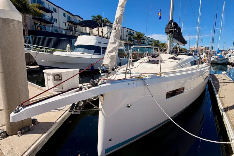 Slide: The Image of 2024 Jeanneau Sun Odyssey 380 yacht docked at a marina under clear blue skies. - 6