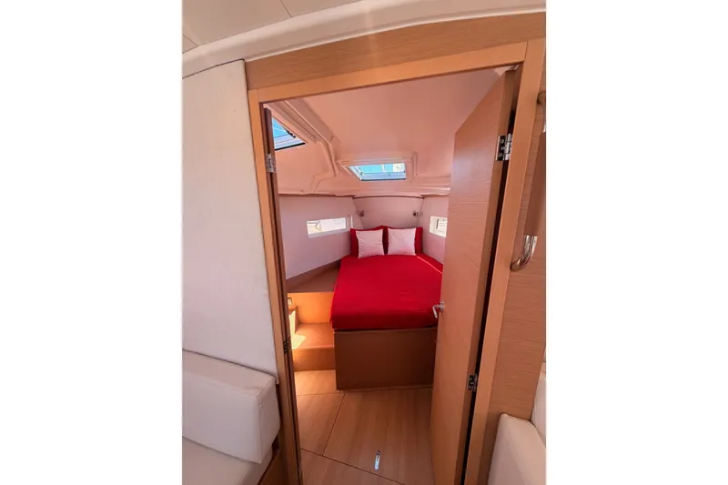 Slide: The Image of Interior cabin of 2024 Jeanneau Sun Odyssey 380 with red bedding and natural light. - 66