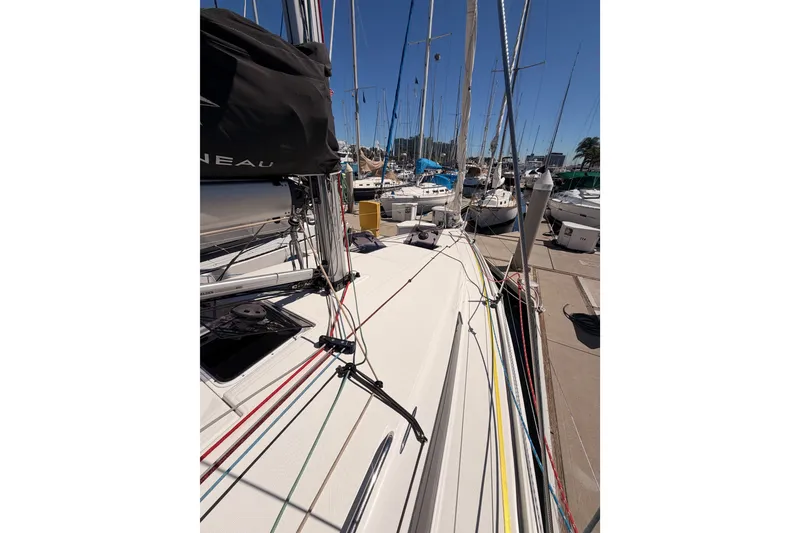 Slide: The Image of 2024 Jeanneau Sun Odyssey 380 sailboat docked at marina, showcasing deck and rigging. - 14